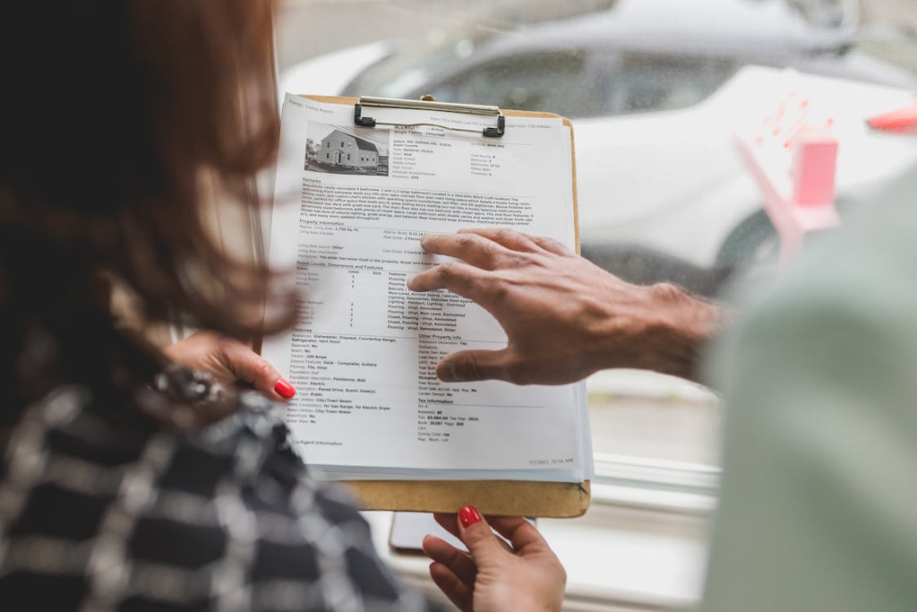 A person holding a document attached to a clipboard