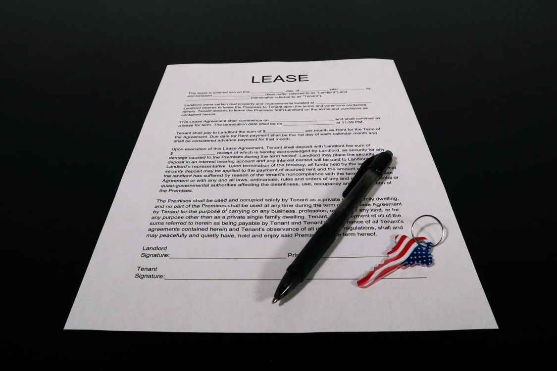keys on a wooden table with a lease document